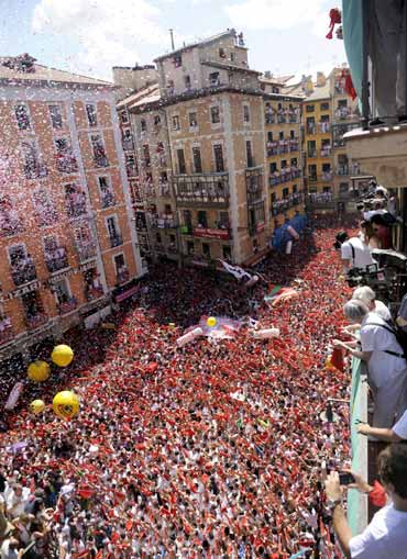 Revellers hold up red scarves during the start of the San Fermin Festival