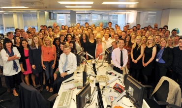 The News Of The World editor, Colin Myler, poses for a photograph with the staff of the newspaper in their newsroom in London