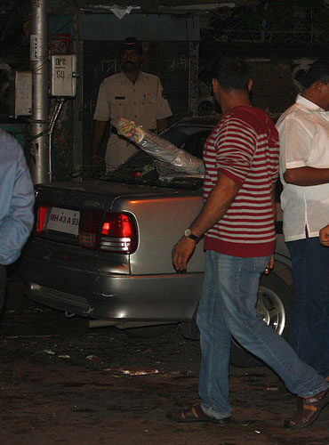 Plainclothed policemen inspect the car