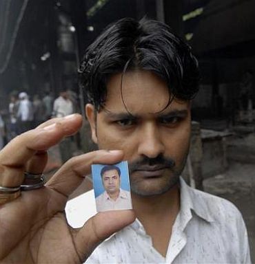 Mahant Mandal displays a passport photograph of his brother Kishan, who was killed in one of the three blasts that took place on Wednesday