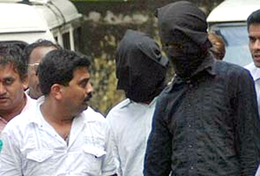 Police leading away two suspected Indian Mujahideen suspects in Mumbai on July 12