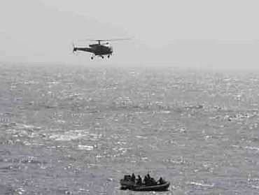 Helicopter from INS Godavari and the marine commandos' boat proceeding to intvestigate the pirate boat