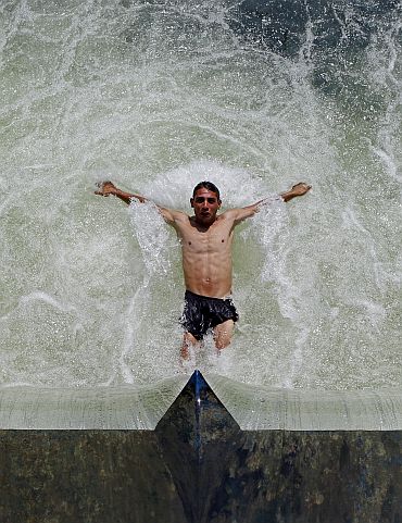 A man cools off in Dambovita river in central Bucharest as temperatures reached 36 degree Celsius (96.8 degree Fahrenheit) in southern Romania