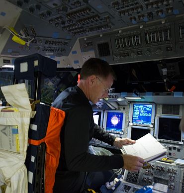 STS-135 Commander Chris Ferguson is pictured at the commander's station on the flight deck of space shuttle Atlantis during the mission's initial day of activities in Earth orbit