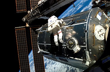 Astronaut Rex Walheim works on the outside of the Columbus laboratory to make it part of the International Space Station.