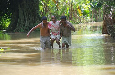 Young boys carry an old woman in Lakhimpur
