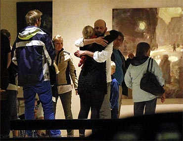 People embrace inside a hotel where relatives of victims and survivors of the shooting gathered