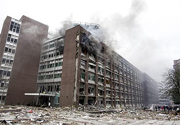 Smoke billows from a building at the site of a powerful explosion that rocked central Oslo