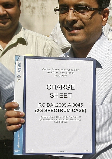 CBI officials carry the 2G spectrum case chargesheet to a court in New Delhi