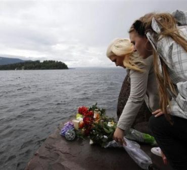 People place flowers in front of Utoeya island, northwest of Oslo