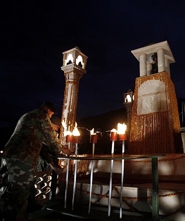 A senior Army officer places a torch at a war memorial during Vijay Diwas celebration in Drass
