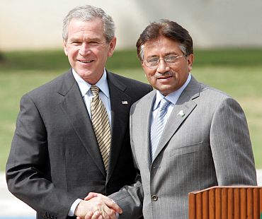 Former Pakistani President Pervez Musharraf shakes hands with visiting former US President George W Bush in Islamabad