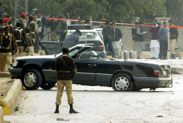 Pakistani soldiers stand guard near former president Musharraf's motorcade car at the site of a suicide blast in Rawalpindi in December, 2003.