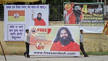 Supporters of Baba Ramdev carry his portrait before raising it in the Ramlila grounds, the venue of his indefinite fast, in New Delhi