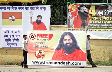 Supporters of Baba Ramdev carry his posters