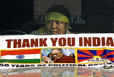 A Tibetan exile holds a banner