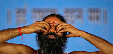 Swami Ramdev performs yoga at the Ramlila Grounds