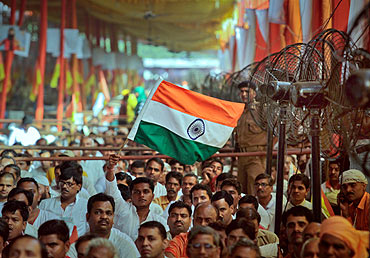 A man waves the national flag during an address by Swami Ramdev