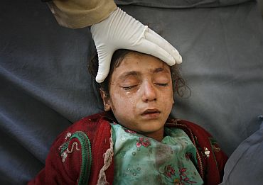 A girl is treated by medics at a hospital after suffering injuries from a bomb attack in Peshawar on February 2, which killed nine people