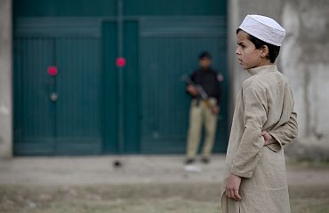 A boy stands in front of the front gates of a compound in Abbottabad, Pakistan where Al Qaeda chief Osama bin Laden was staying before he was killed by US forces
