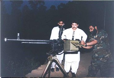 Exclusive Image: Ilyas Kashmiri (extreme right) shows an anti-aircraft gun to Hamid Mir (centre)