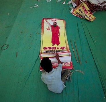 A worker sorts through posters of yoga guru Swami Ramdev