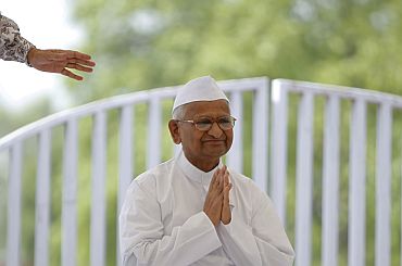 Social activist Anna Hazare clasps his hands together as he greets supporters after arriving for his hunger strike at Rajghat in New Delhi on Wednesday