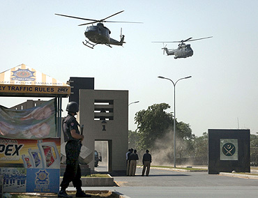 Military helicopters fly over the entrance to Pakistan's army headquarters after an attack by armed terrorists in Rawalpindi in 2009