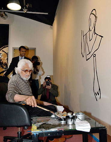 M F Husain paints during an exhibition in New York