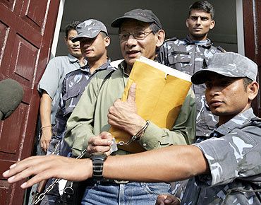 Sobhraj comes out of a court in Kathmandu surrounded by security personnel