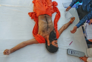 Ramdev, lying on stage, gets a medical check-up during his fast against corruption
