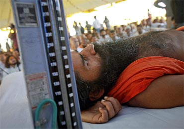 Ramdev, lying on stage, gets a medical check-up done during his fast against corruption
