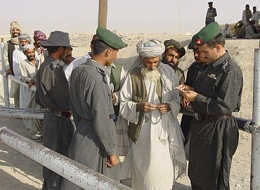 Pakistani para-military soldiers check travel documents of Afghans entering Pakistan at the border of Chaman, near Quetta