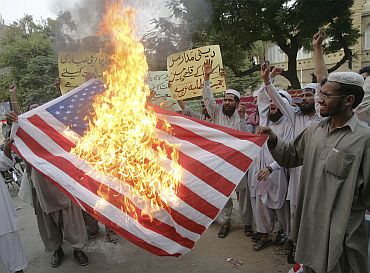 Activists of Jamiat Talba-e-Arabia group burn a US flag during a protest in Karachi