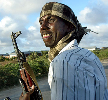 A Somali gunmen sits at the back of a pickup truck as their drive through the streets of Mogadishu