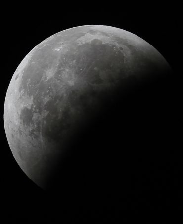 The moon is partially visible during a total lunar eclipse over Ahmedabad