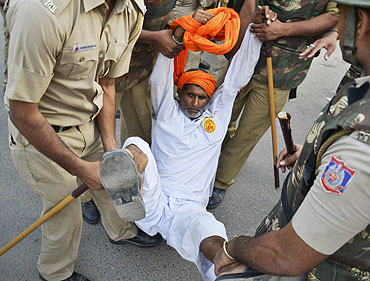 A supporter of yoga guru Baba Ramdev is detained by police at the Ramlila grounds