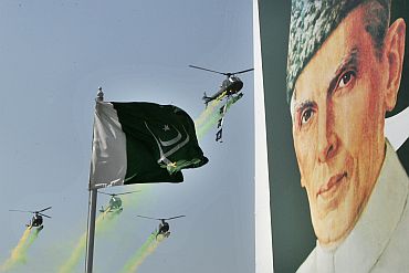 Pakistani army helicopters fly past the portrait of country's founder Mohammad Ali Jinnah during the National Day military parade in Islamabad