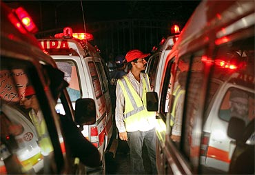 A rescue worker stands between ambulances lined outside the Mehran naval aviation base