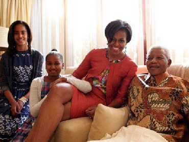 Michelle Obama, accompanied by her daughters, Malia and Sasha, meet Mandela at this home