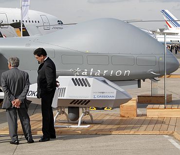 Visitors look at Eurocopter drones Talarion and Cassidan during the 49th Paris Air Show