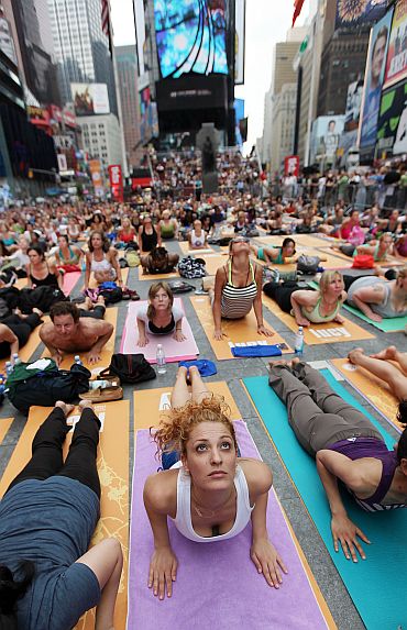 Naty Horev (C) and other enthusiasts perform yoga in Times Square