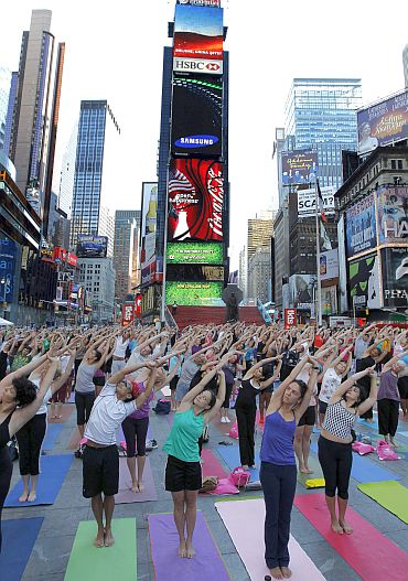 People gather to practice yoga on the morning of the summer solstice in New York's Times Square