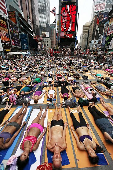 Enthusiasts perform yoga in Times Square during an event marking the summer solstice