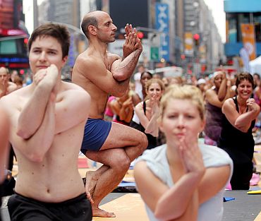 Enthusiasts perform yoga in Times Square