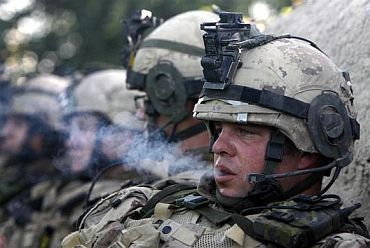 A soldier smokes during a lull in fighting against Taliban insurgents in Sangasar, Zari district