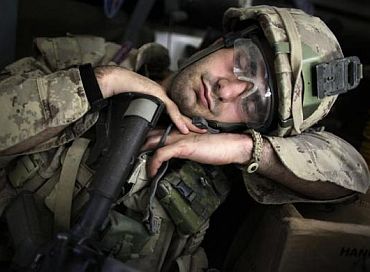A soldier takes a nap after taking part in an operation in Kandahar