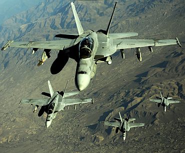 Four US Navy F/A-18 Hornet aircraft fly over mountains in Afghanistan