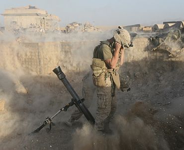 A US Marine fires a mortar round during combat operations at Forward Operating Base Nolay, Afghanistan