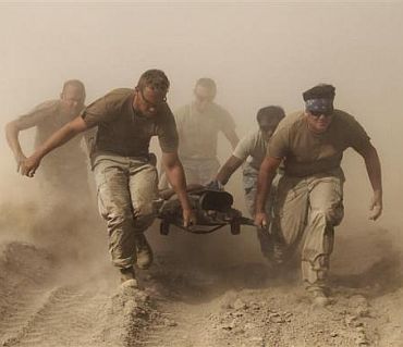 Members of the US Navy carry a comrade wounded by an explosion to a medevac helicopter in Kandahar province in southern Afghanistan